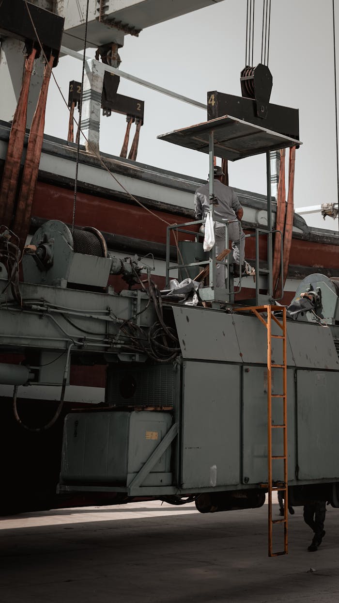 hero-img-02 Worker performing maintenance on heavy industrial equipment outdoors.