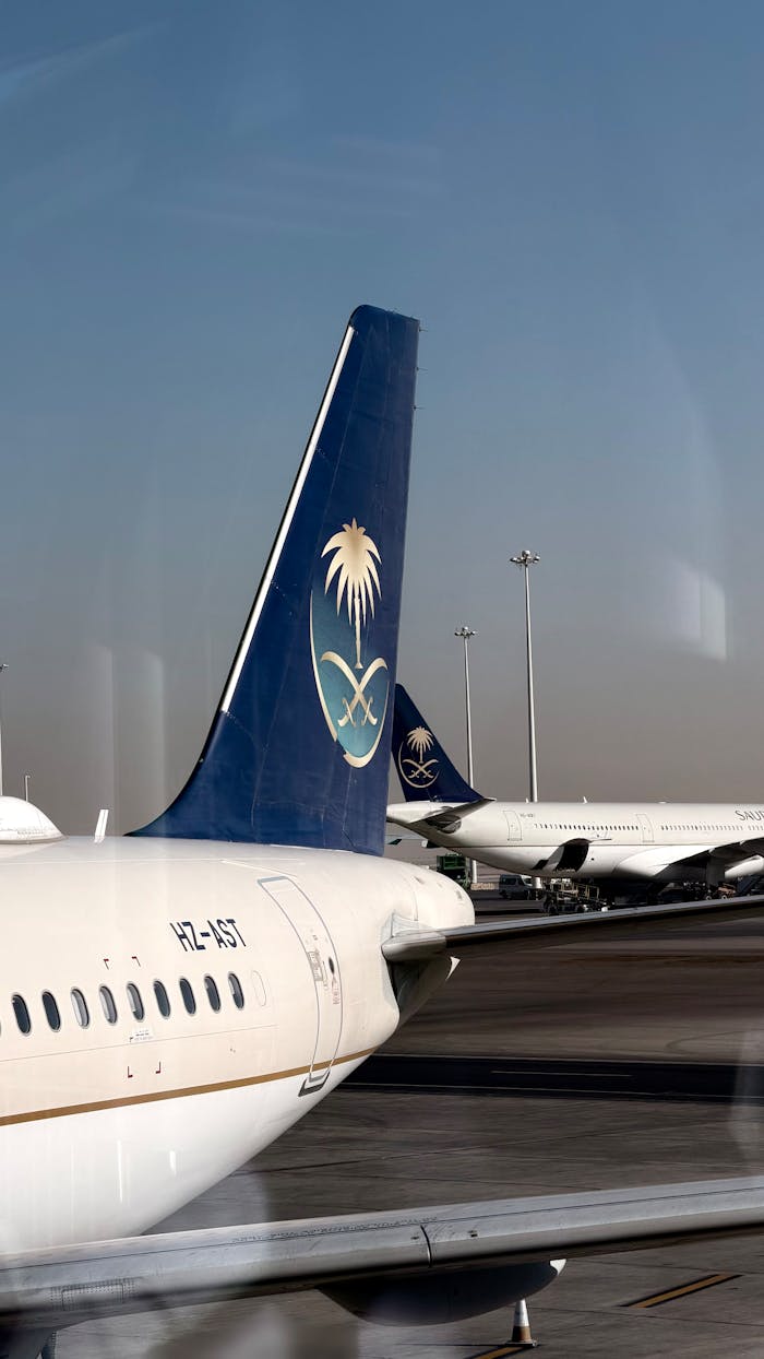 about-01 Saudia Airlines aircraft parked on the tarmac at an airport terminal under a clear sky.